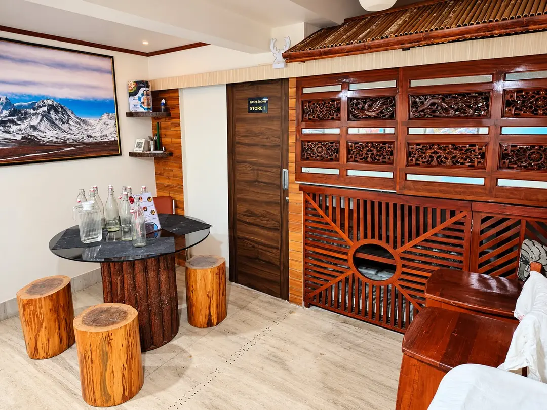 Dining corner with log stools and carved timber screens