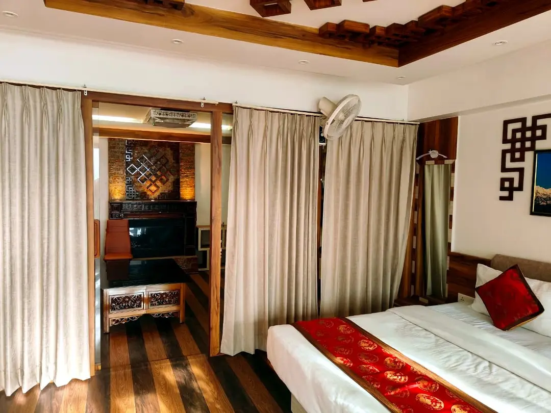 View from the suite bedroom through curtained openings into the sitting room with its carved fireplace surround