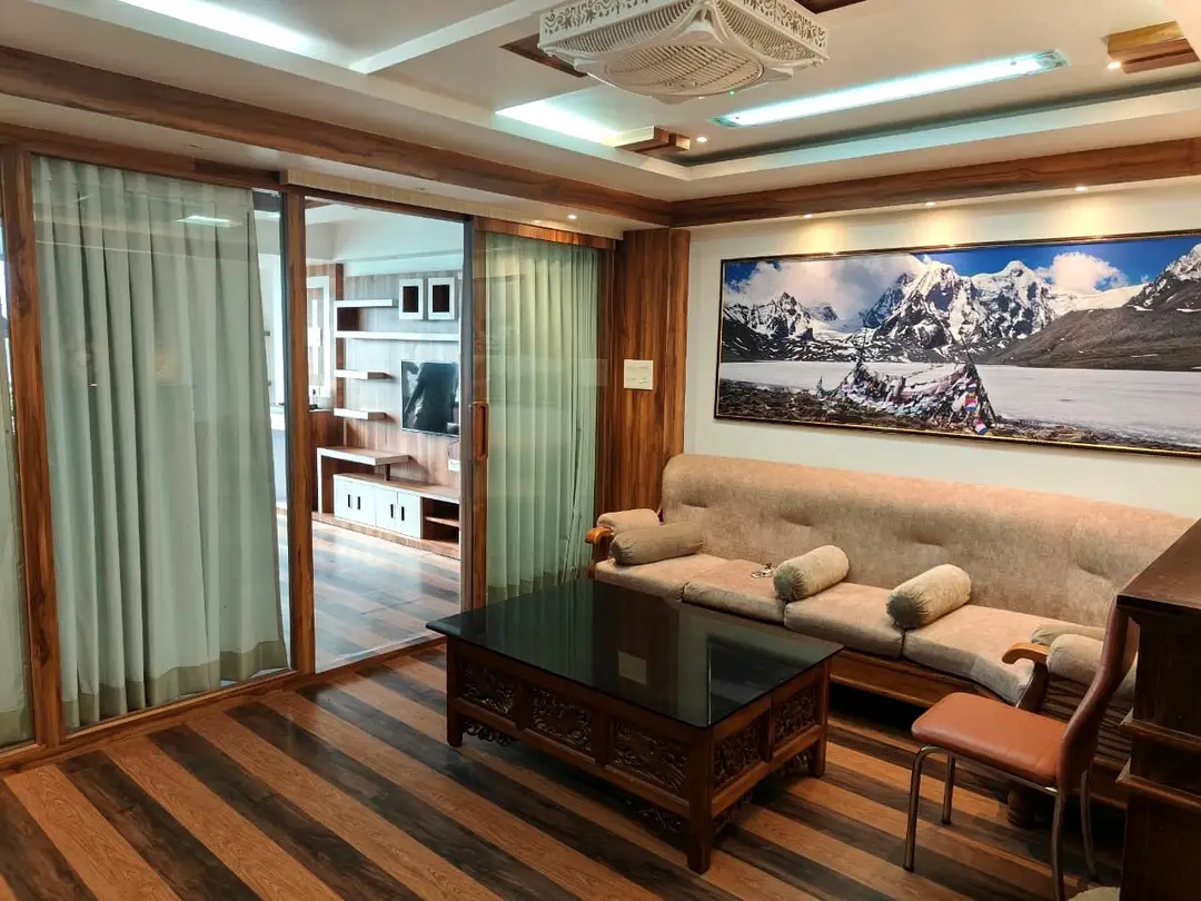 Suite sitting room with a long sofa, hand-carved coffee table and sliding glass doors